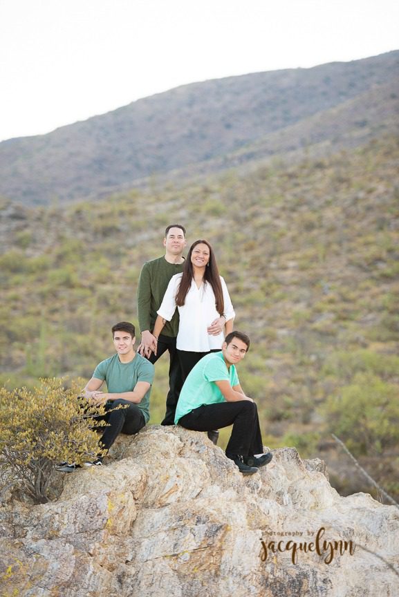 family standing on a rick in the desert in tucson