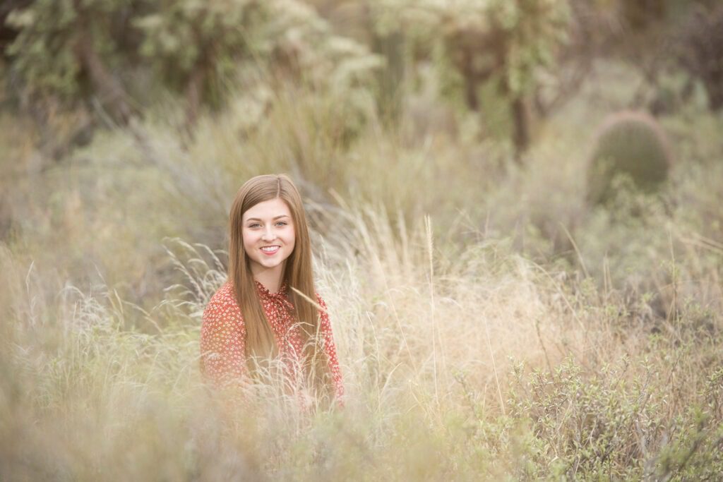 girl in grass wearing flowered shirt